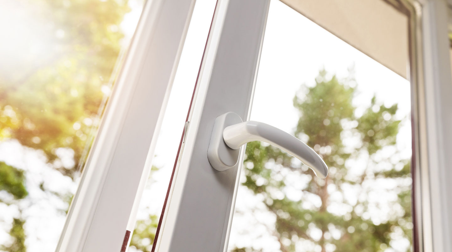 Artisan RGE installant fenêtre double vitrage haute performance sur façade maison française, étiquette énergétique classe A visible en français, niveau à bulle digital, outils professionnels au sol